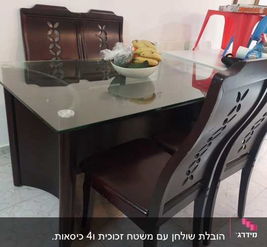 שולחן זכוכית עם כיסאות עץ וקערת פירות